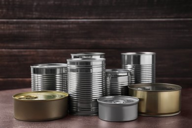 Photo of Many closed tin cans on brown table