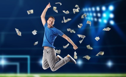 Image of Sports betting. Happy man jumping under money shower. Stadium on background