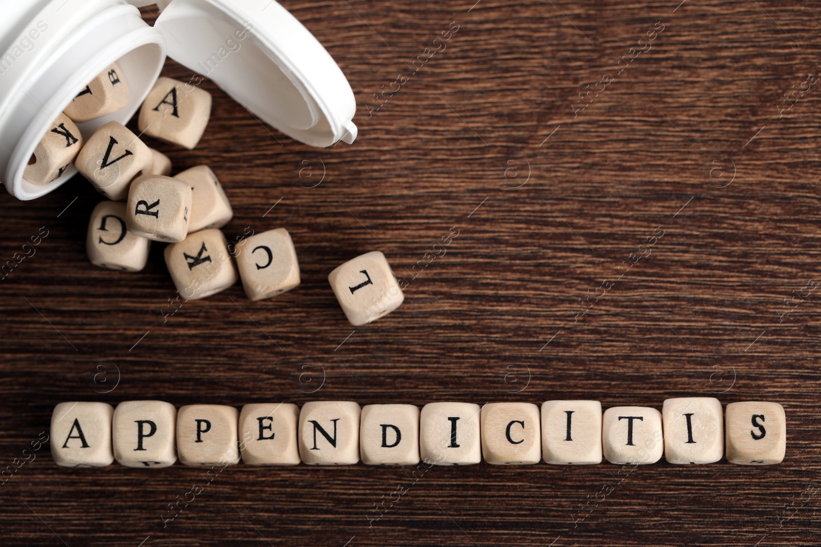 Photo of Word Appendicitis made of cubes and jar on wooden table, flat lay. Space for text