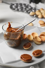 Delicious walnut shaped cookies with condensed milk on table