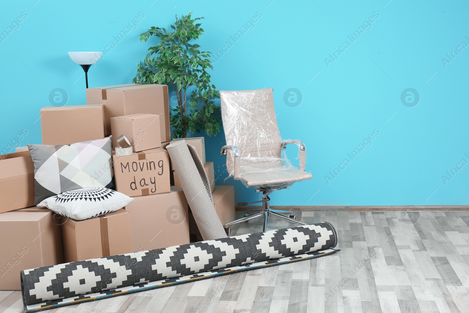 Photo of Cardboard boxes and household stuff in empty room, space for text. Moving day