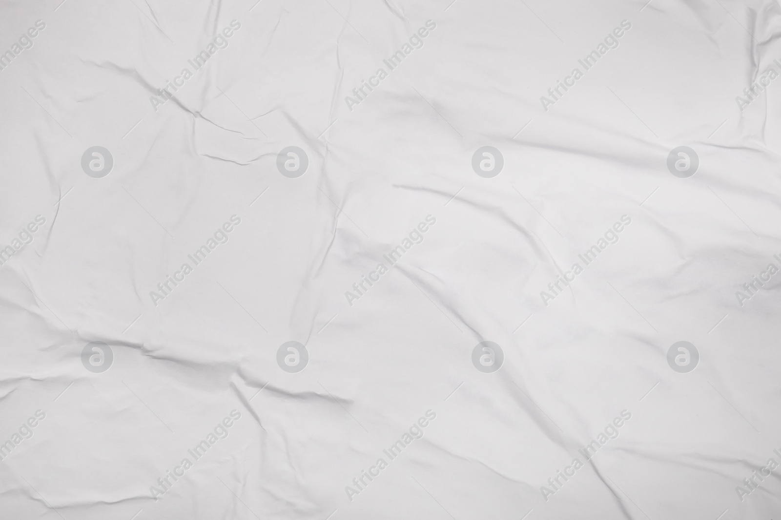 Photo of Top view of white creased blank poster as background, closeup