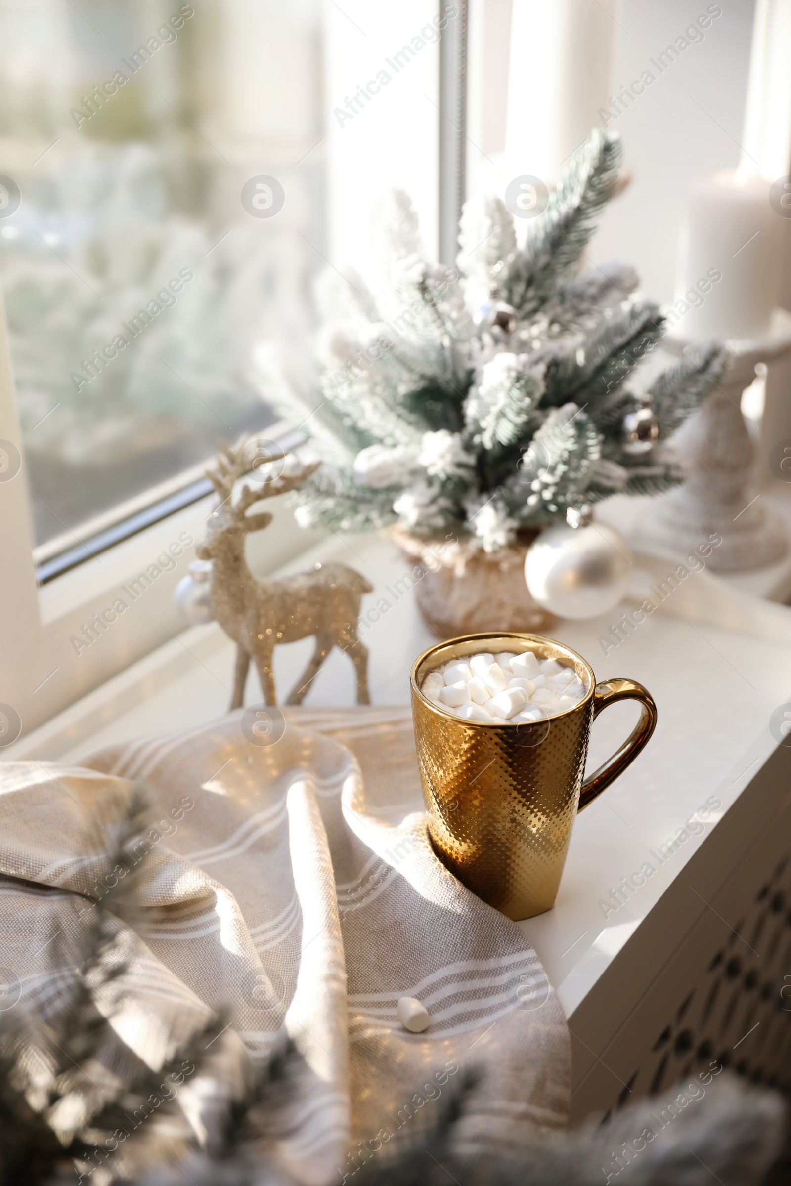 Photo of Golden cup of cocoa and Christmas decor on window sill indoors