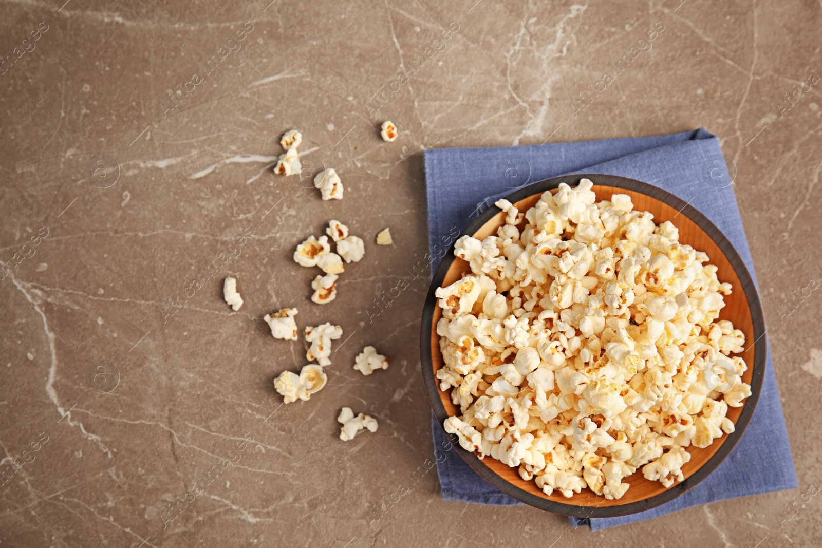 Photo of Bowl of tasty popcorn on grey background, top view