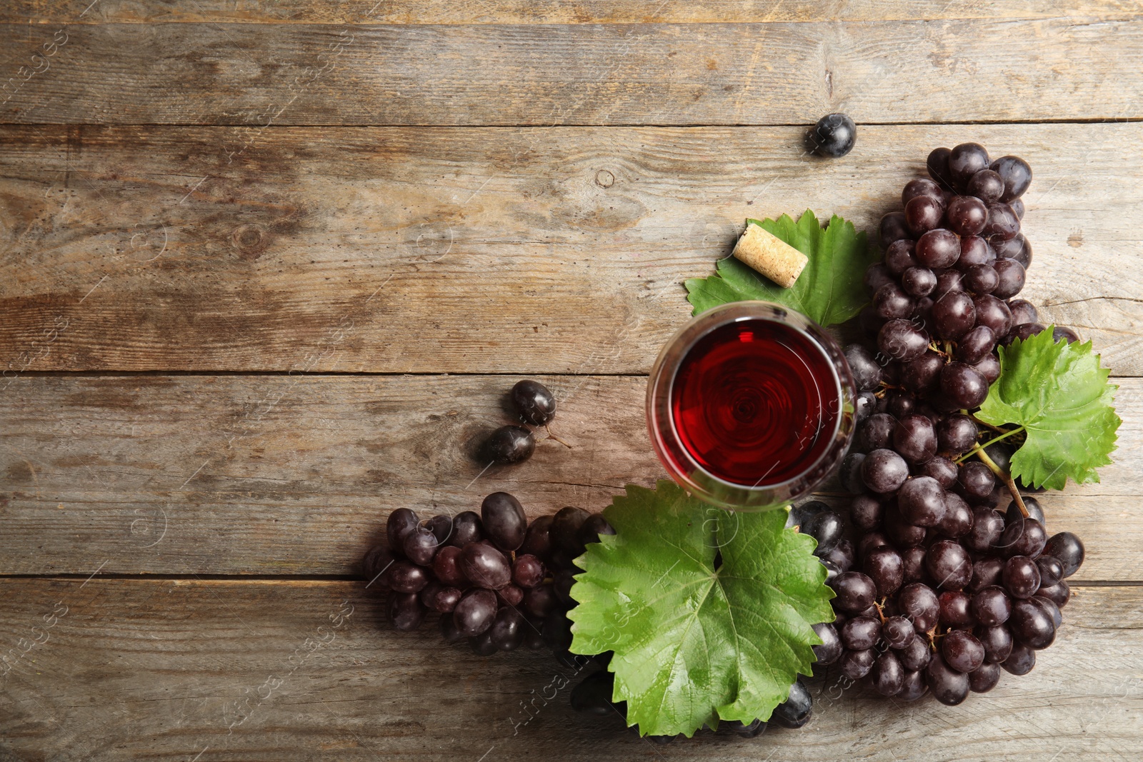 Photo of Flat lay composition with fresh ripe juicy grapes and space for text on wooden background