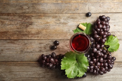 Photo of Flat lay composition with fresh ripe juicy grapes and space for text on wooden background