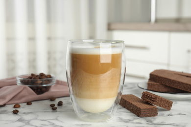 Photo of Delicious wafers and coffee for breakfast on white marble table