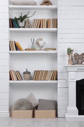 Photo of Collection of books and decor elements on shelves indoors. Interior design