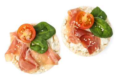 Photo of Puffed rice cakes with prosciutto, tomato and basil isolated on white, top view