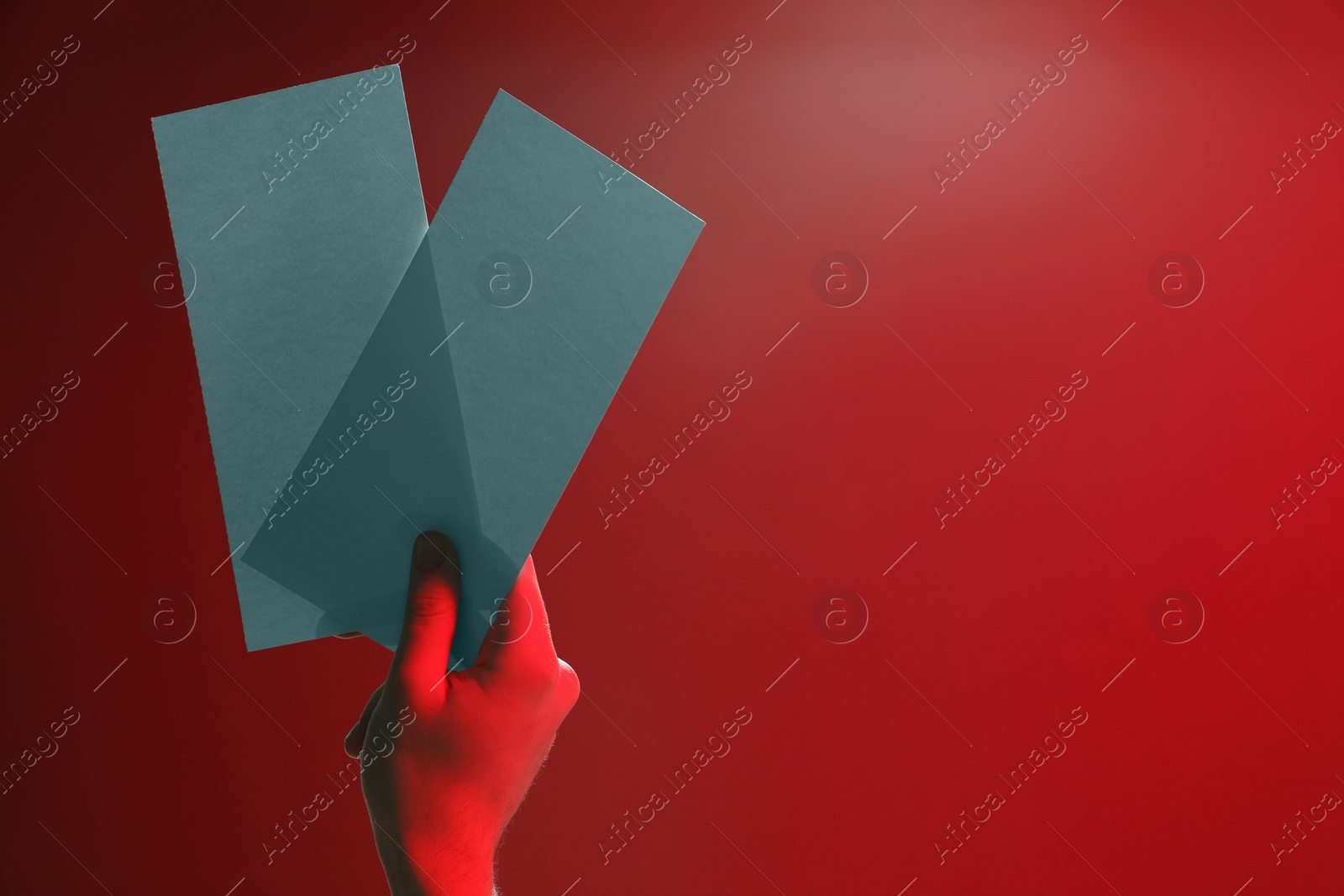 Photo of Man holding flyers on red background, closeup and space for text. Color tone effect