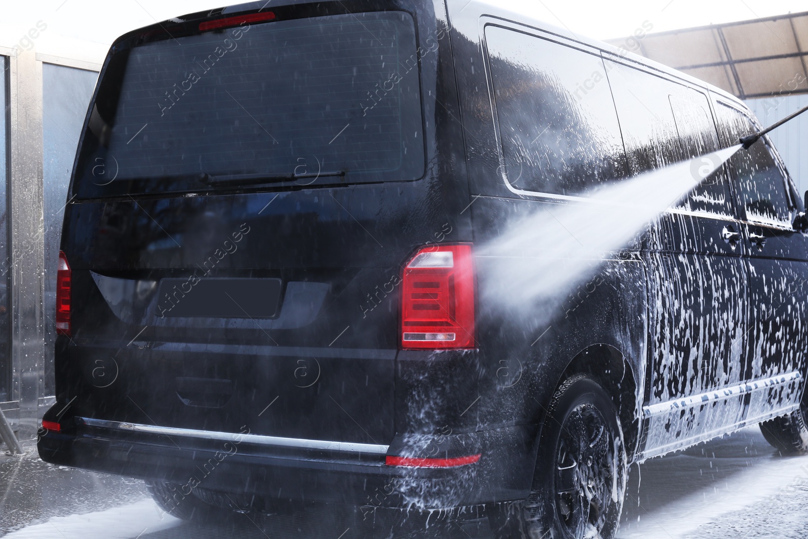 Photo of Cleaning automobile with high pressure water jet at car wash