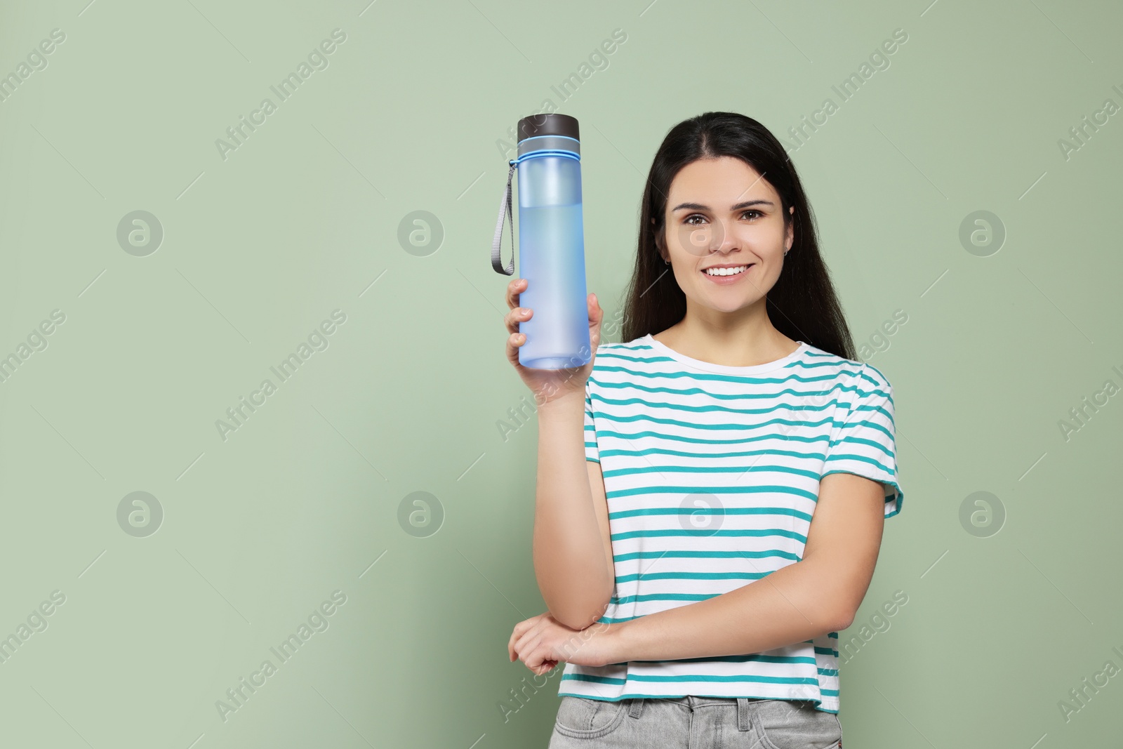 Photo of Young woman with bottle of water on green background. Space for text