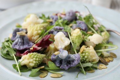Photo of Delicious salad with cauliflower and pumpkin seeds in plate, closeup