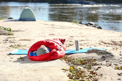 Photo of Male camper lying in sleeping bag on wild beach