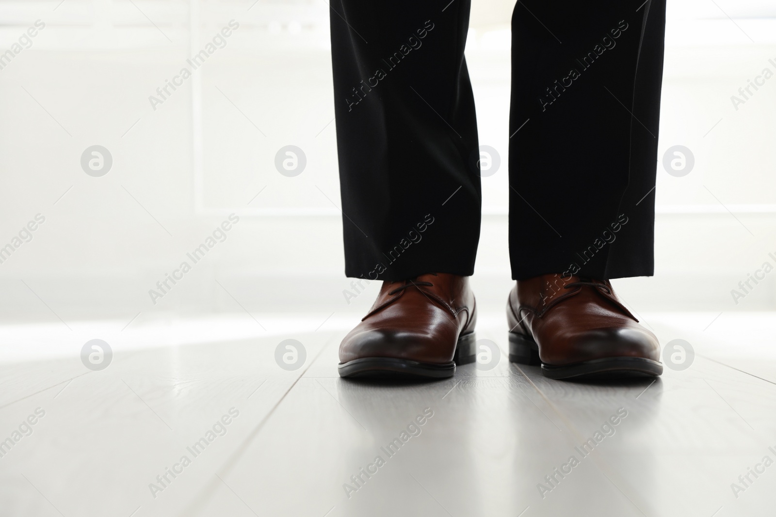 Photo of Groom wearing elegant wedding shoes indoors, closeup