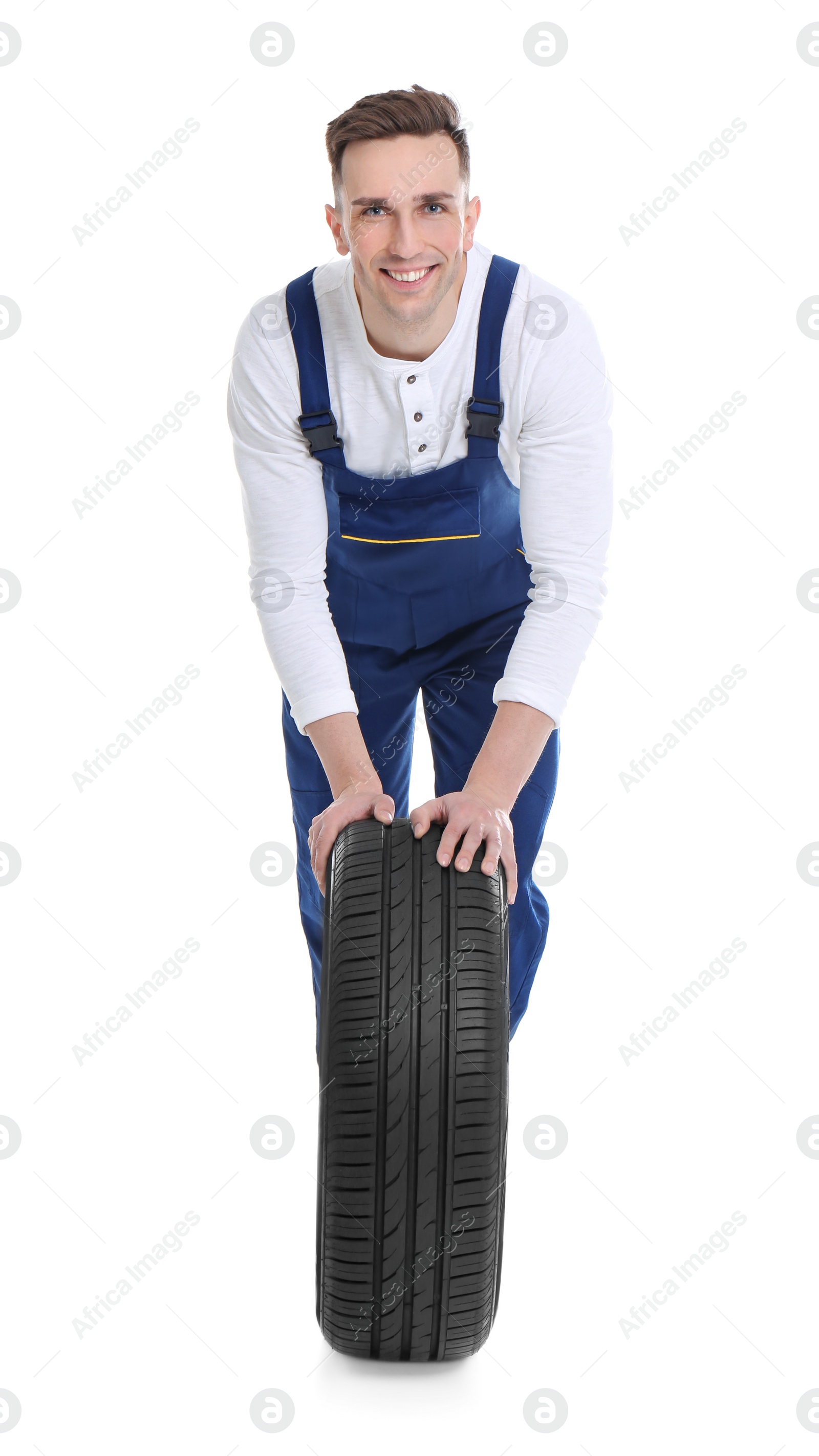 Photo of Male mechanic with car tire on white background