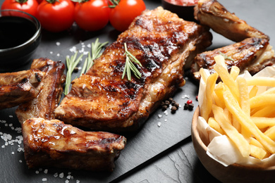 Photo of Delicious grilled ribs on black table, closeup