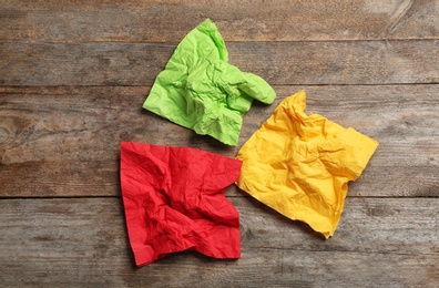 Photo of Crumpled napkins on wooden background, top view. Personal hygiene