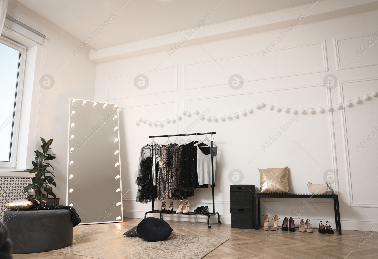 Photo of Stylish dressing room interior with trendy clothes and shoes