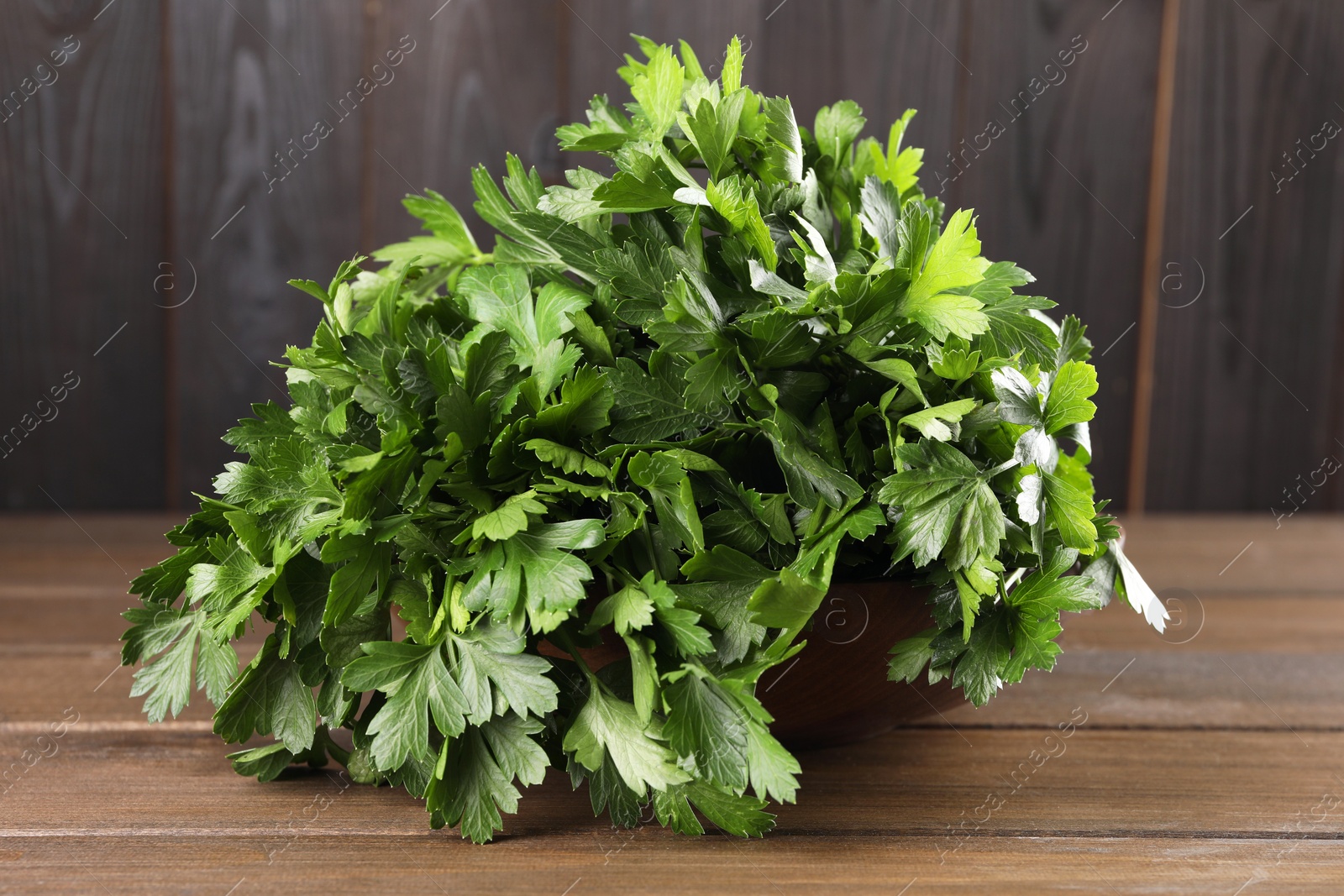 Photo of Bunch of fresh parsley on wooden table