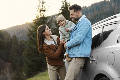 Photo of Parents and their daughter near car in mountains. Family traveling