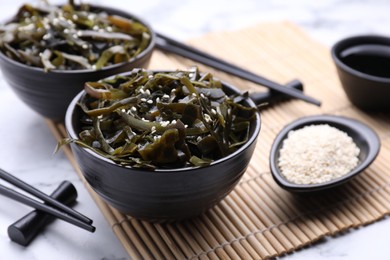 Photo of Fresh laminaria (kelp) seaweed served on white marble table