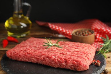 Photo of Raw fresh minced meat and other ingredients on wooden table, closeup