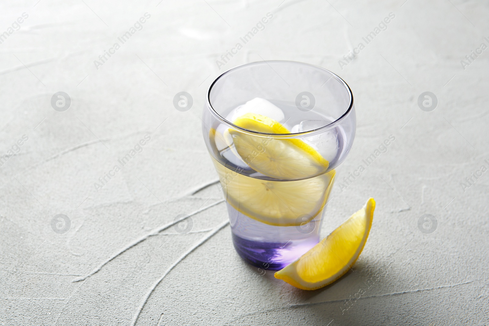 Photo of Glass with lemon water on table