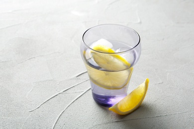 Glass with lemon water on table