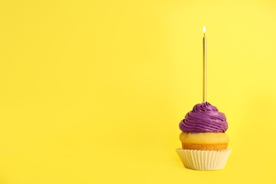 Photo of Birthday cupcake with candle on yellow background, space for text