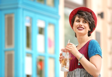 Photo of Young woman with cup of tasty lemonade outdoors