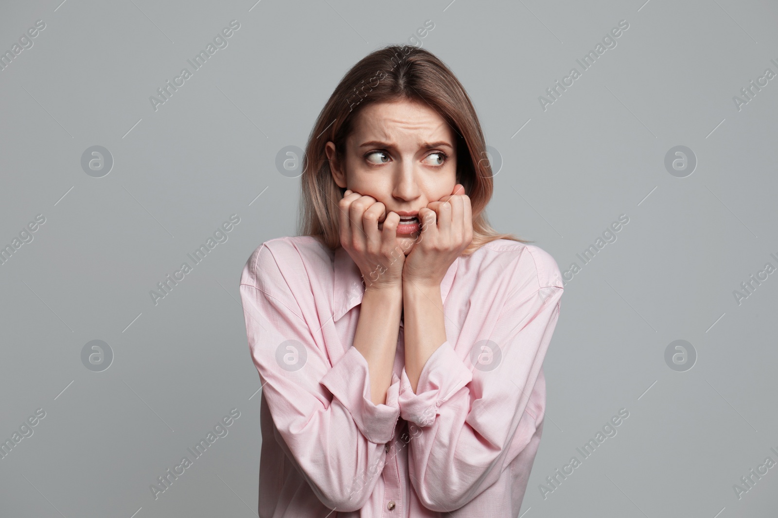 Photo of Young woman feeling fear on grey background