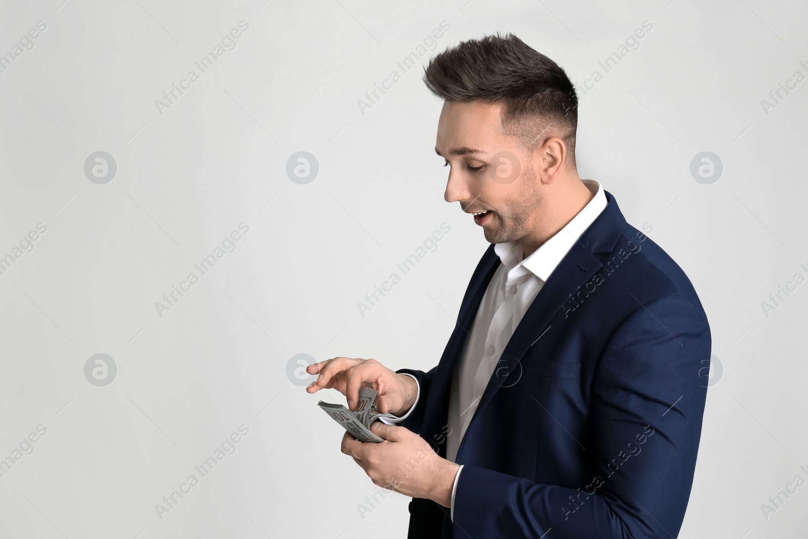 Photo of Man counting money on light grey background. Space for text