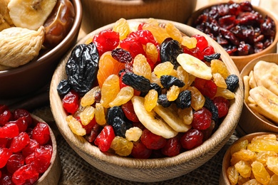 Photo of Bowls with different dried fruits on table, closeup. Healthy lifestyle