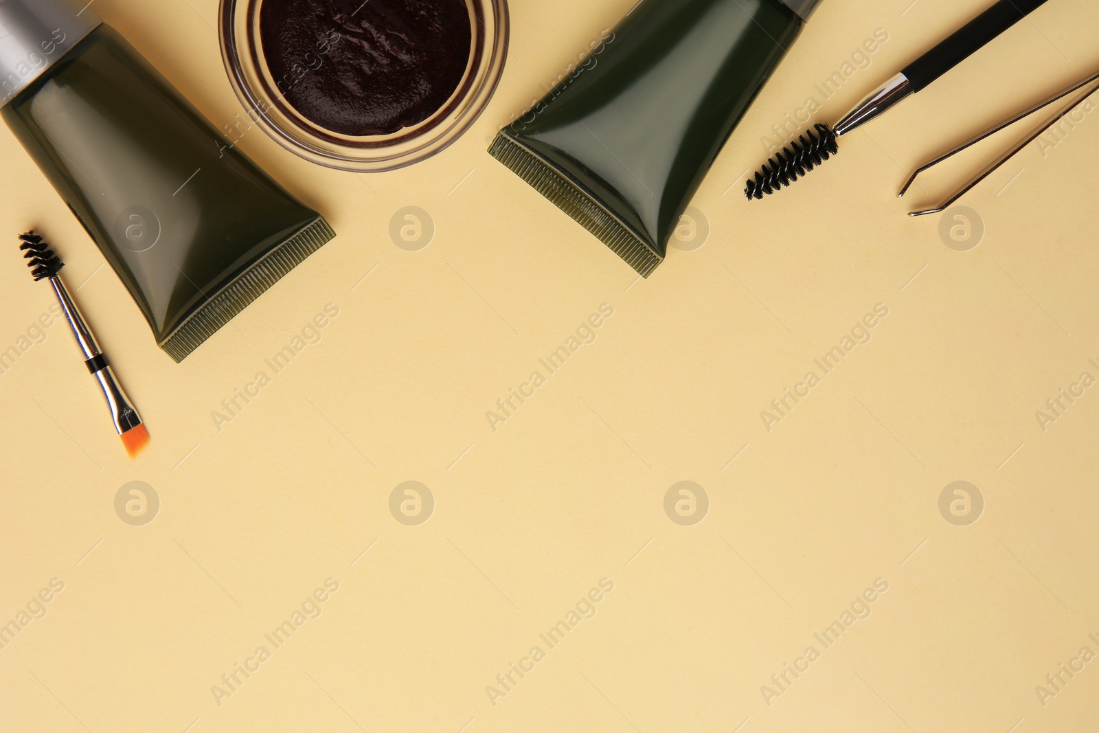 Photo of Flat lay composition with eyebrow henna and tools on beige background. Space for text