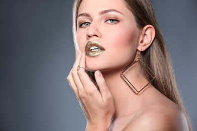 Photo of Portrait of beautiful lady with gold lipstick on grey background. Space for text