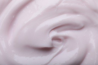 Photo of Closeup view of light pink body cream as background