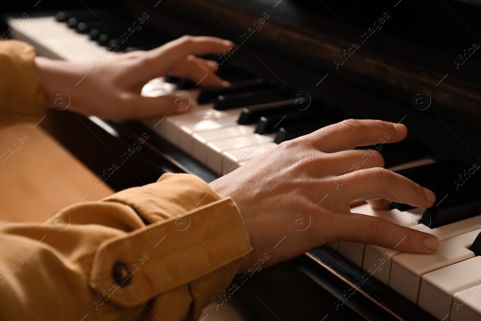 Photo of Young woman playing piano, closeup. Music lesson