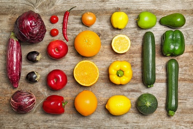 Photo of Rainbow composition with fresh vegetables and fruits on wooden background, flat lay