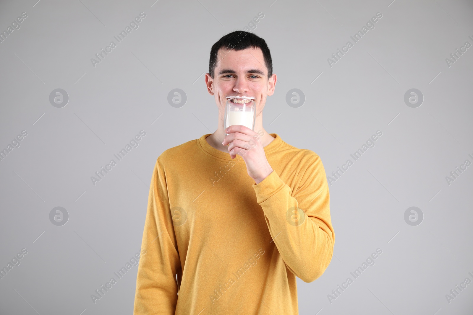 Photo of Milk mustache left after dairy product. Man drinking milk on gray background