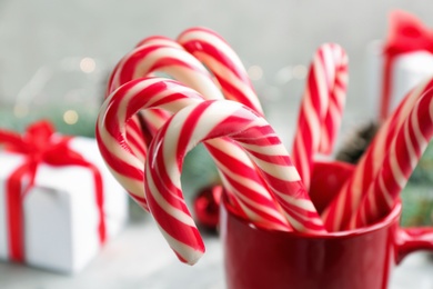Many sweet candy canes in cup, closeup. Traditional Christmas treat