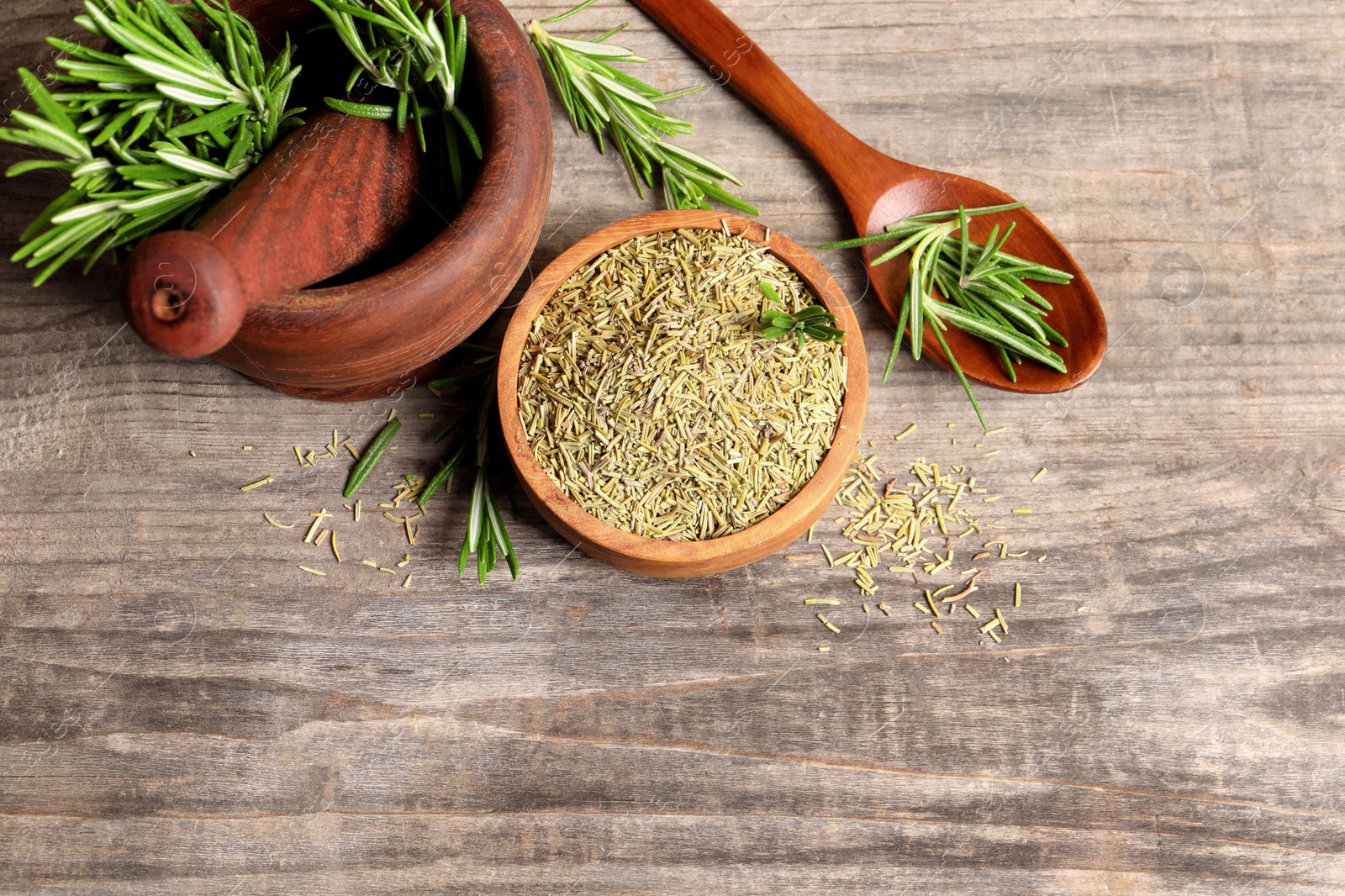 Photo of Fresh and dry rosemary on wooden table, flat lay. Space for text