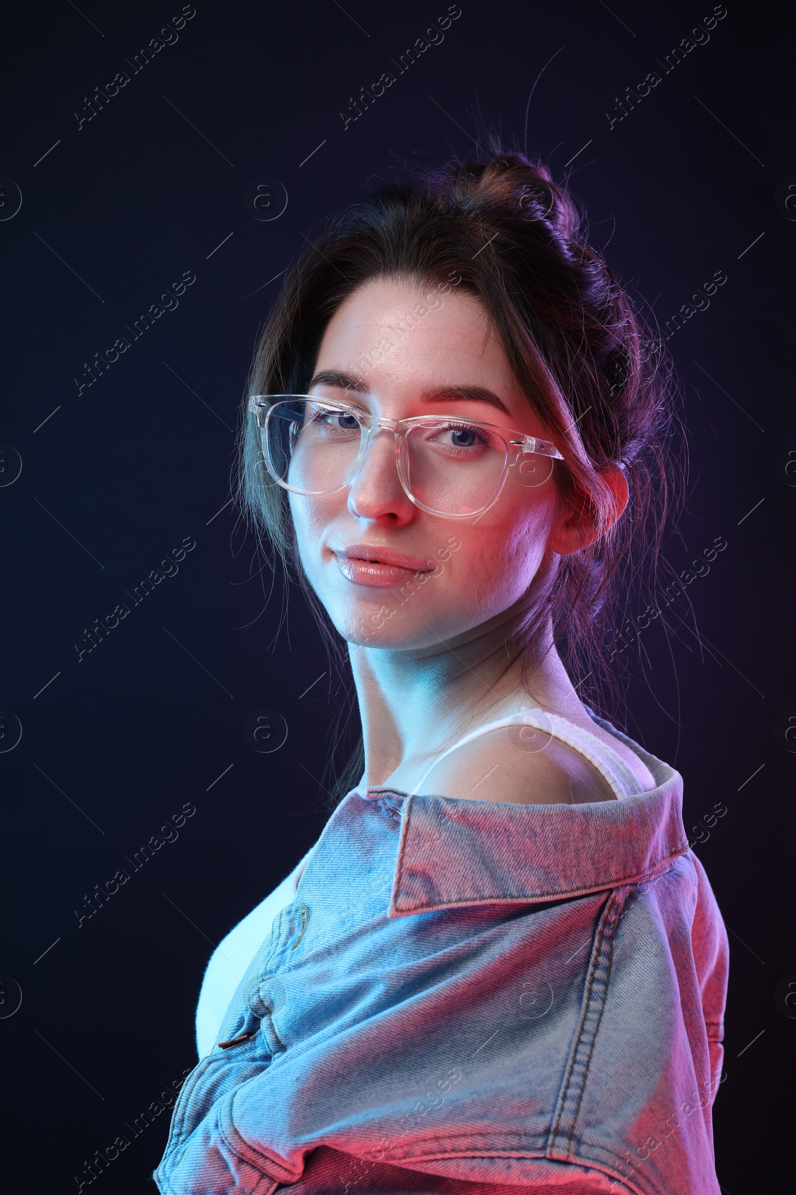 Photo of Portrait of beautiful young woman in glasses on color background