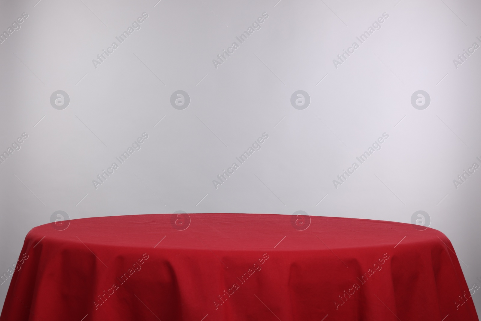 Photo of Empty table with red tablecloth isolated on white