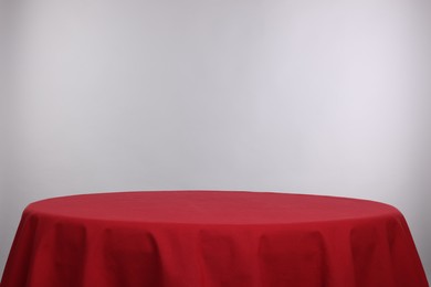 Photo of Empty table with red tablecloth isolated on white