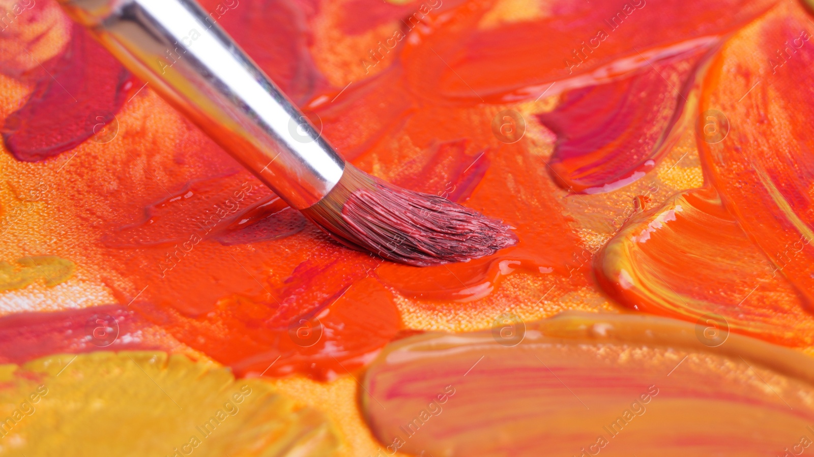 Photo of Brush on artist's palette with mixed paints, closeup