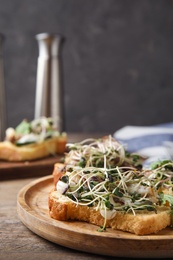 Delicious bruschettas with fish on wooden table