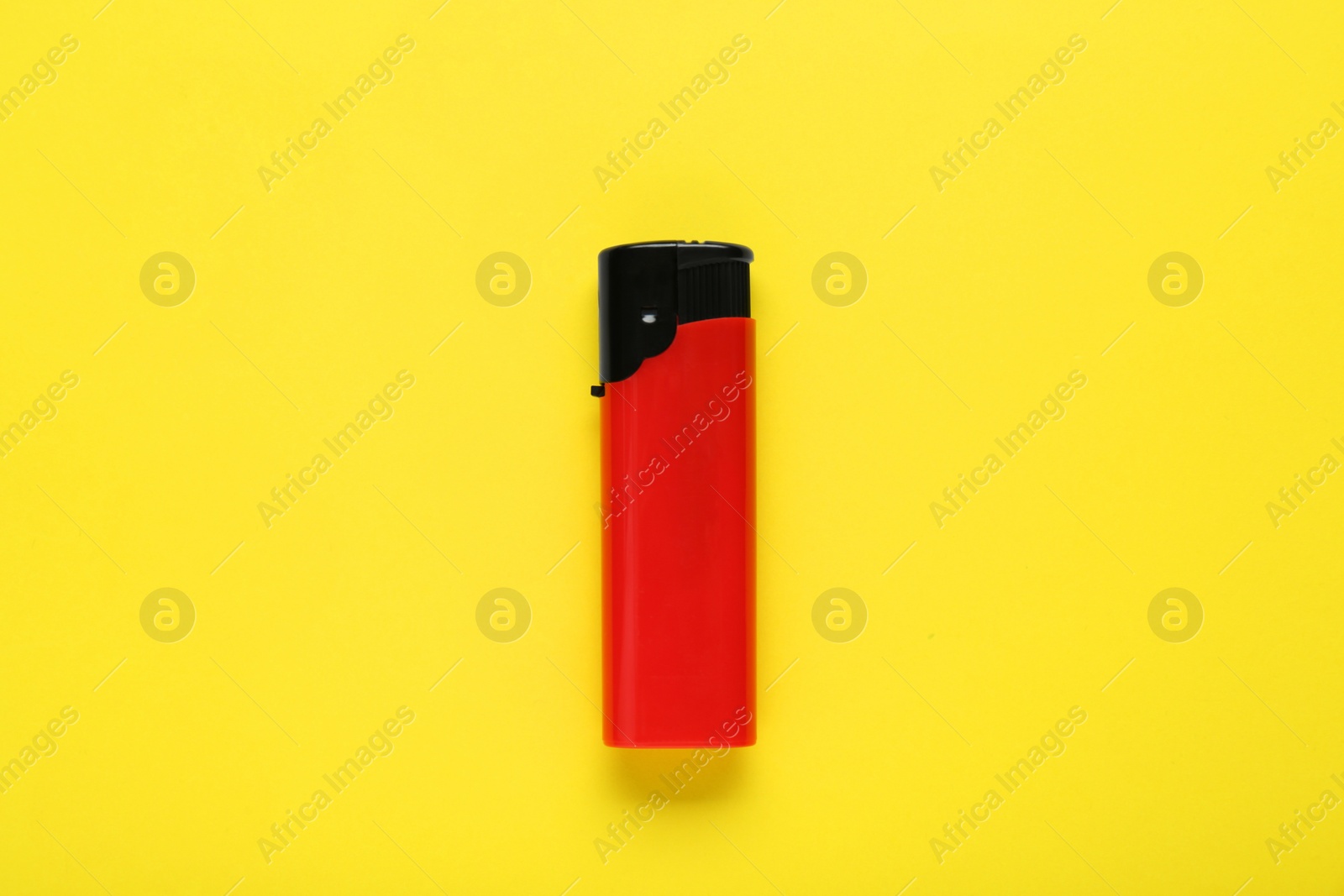 Photo of Stylish small pocket lighter on yellow background, top view