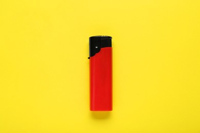 Photo of Stylish small pocket lighter on yellow background, top view