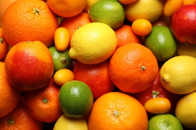 Different ripe citrus fruits as background, closeup